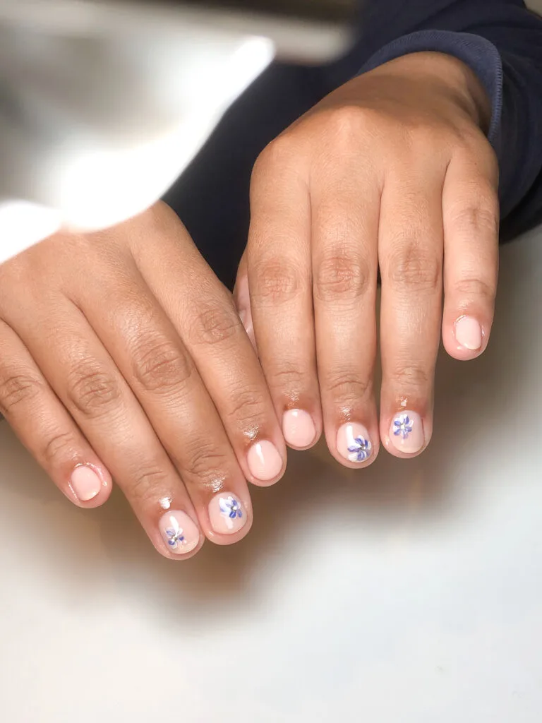 Nail art natural dengan aksen bunga mungil