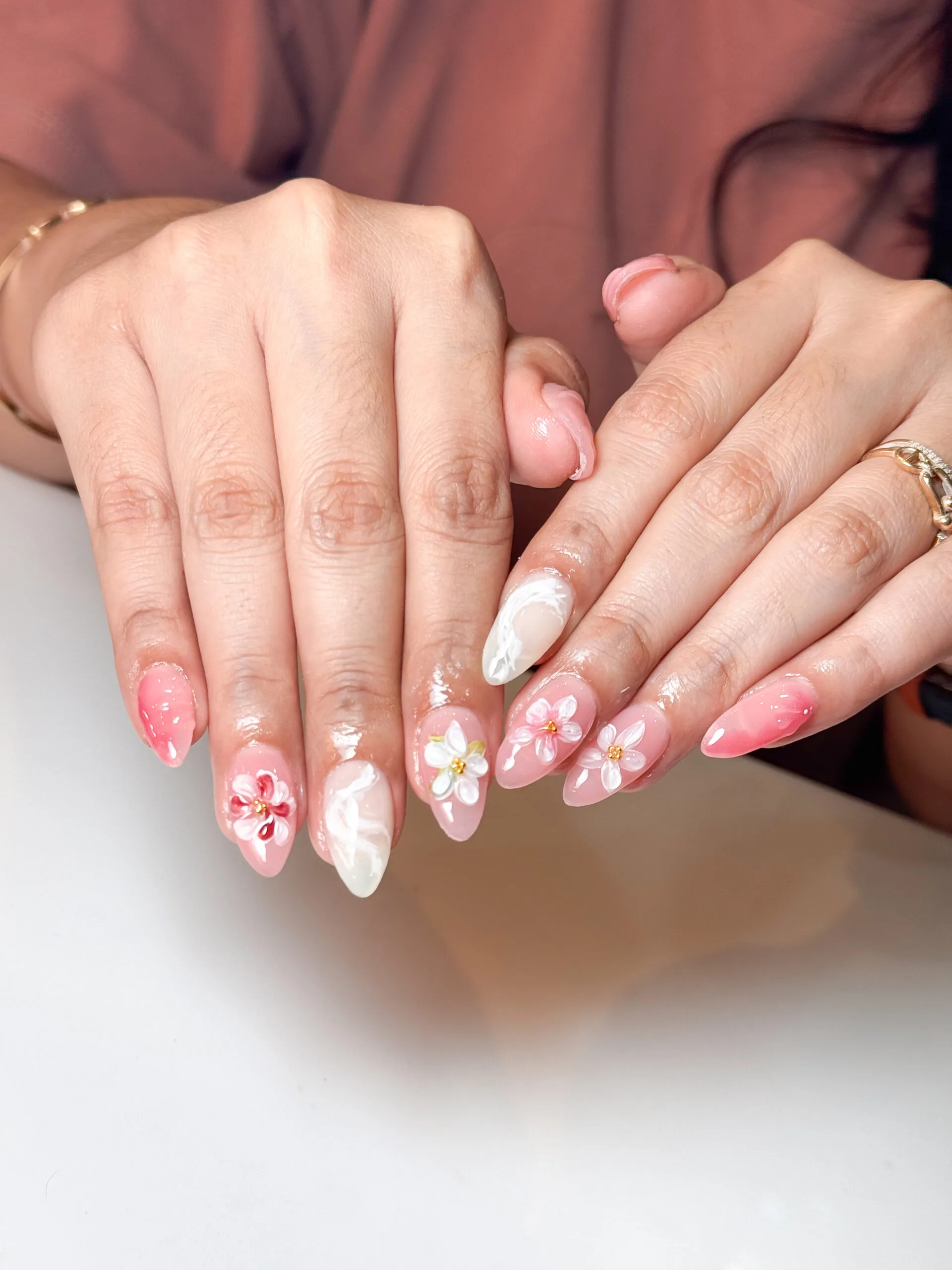 Nail art nude dengan hiasan bunga kecil warna pink