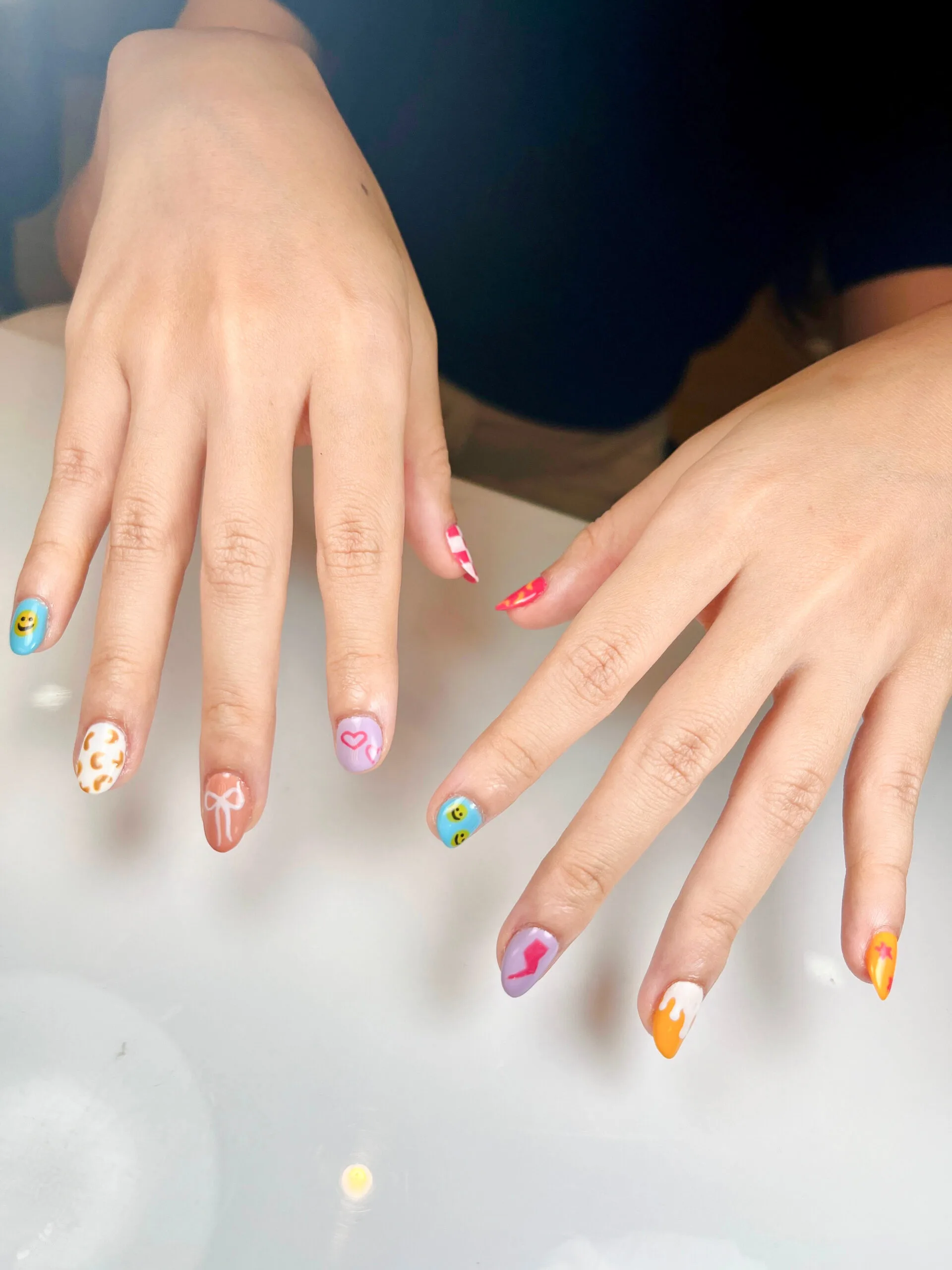 Nail art warna-warni dengan desain berbeda di tiap kuku